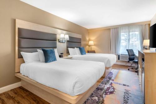 南波特兰Casco Bay Hotel, Ascend Hotel Collection的酒店客房配有两张床和一张书桌