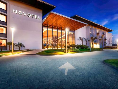 伊图Novotel Itu Terras de São José Golf & Resort的指向夜间的一座建筑的箭头