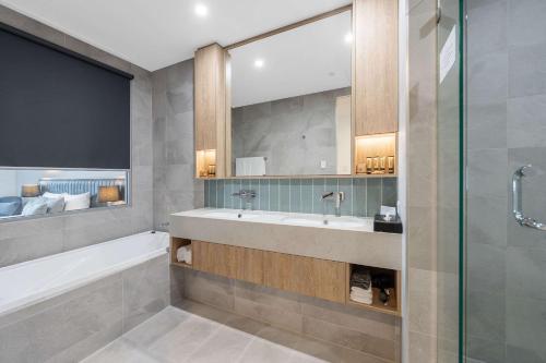 珀斯Ingot Hotel Perth, Ascend Hotel Collection的带浴缸、水槽和淋浴的浴室