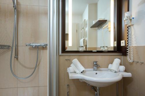 韦斯特兰Hapimag Resort Aalborg的浴室配有盥洗盆和带镜子的淋浴