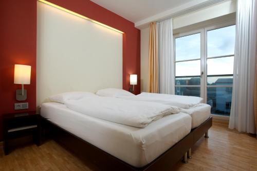 韦斯特兰Hapimag Resort Aalborg的一张大床,位于带大窗户的房间里