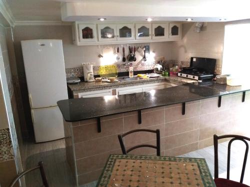 马拉喀什Shared apartment-Appartement en colocation tout confort centre ville的厨房配有冰箱和桌椅