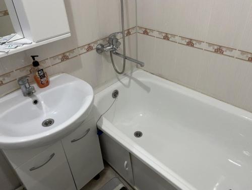 阿特劳Однокомнатная квартира в Жилгородке рядом с ДостарМед的浴室配有盥洗盆、卫生间和浴缸。