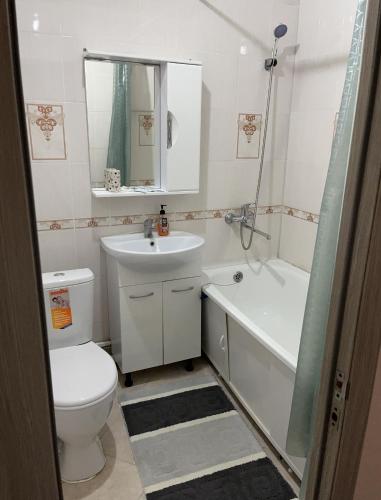 阿特劳Однокомнатная квартира в Жилгородке рядом с ДостарМед的浴室配有卫生间、盥洗盆和浴缸。