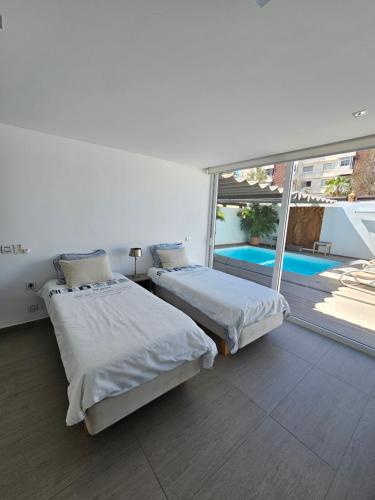 洛斯克里斯蒂亚诺斯Nosotros Luxury Villa的游泳池景客房 - 带两张床