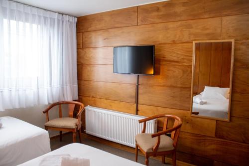 巴拉斯港Hotel Germania的酒店客房设有两张床和一台平面电视。