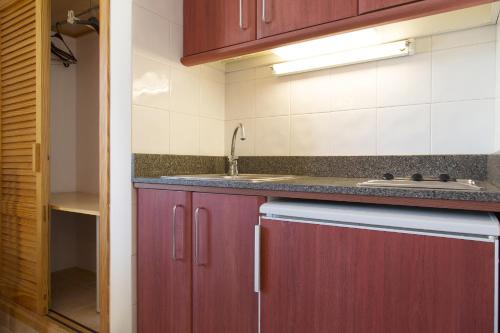 圣安东尼奥玛丽亚之家公寓的一间带红色橱柜和水槽的厨房