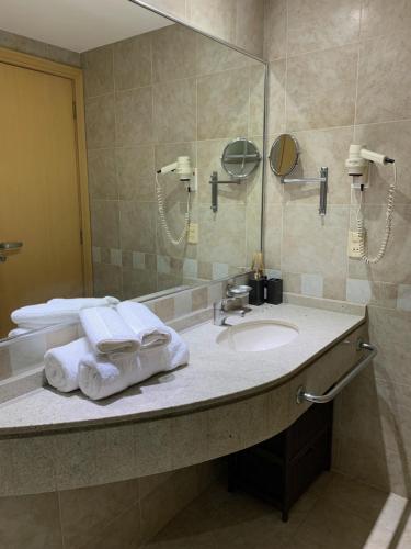 圣保罗King room - Brooklin flat的浴室配有盥洗盆、镜子和毛巾