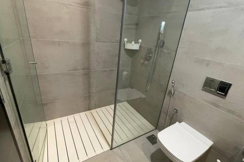 麦纳麦Cloud9 Waterfront Luxury Condo的浴室设有玻璃淋浴间和卫生间