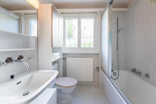 莱克斯LAAX Homes - Casa Gronda 2的白色的浴室设有水槽和卫生间。