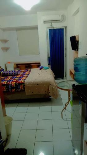 ParungtandjungSewa apartemen/transit gunung putri square Bogor的一间卧室配有床和蓝色窗帘