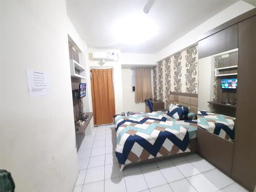 ParungtandjungSewa apartemen/transit gunung putri square Bogor的一间卧室配有一张床和一台电视