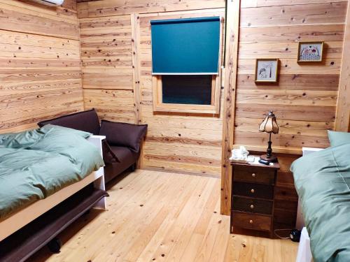 壹岐市Shimanologhouse - Vacation STAY 41662v的小木屋卧室设有两张床和窗户