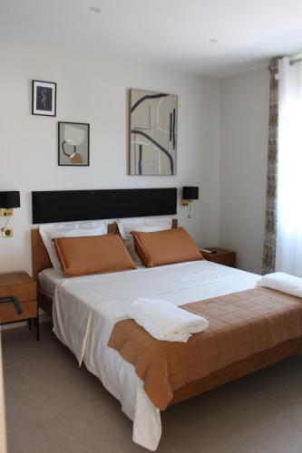 旺德尔港Villa plain pied vue terrasse的卧室配有一张带白色床单和橙色枕头的大床。
