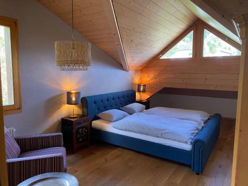 萨尔嫩Chalet Seeblick的阁楼卧室配有蓝色床