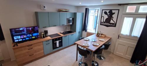 莱萨布勒-多洛讷CANTETEAU - Agreable maison chaleureuse et conviviale的厨房配有蓝色橱柜和桌椅