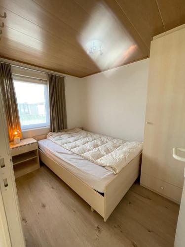 米德尔克尔克Chalet n°32的一间小卧室,配有床和窗户