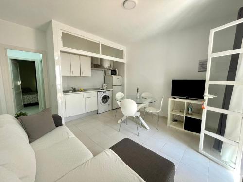 奇克拉纳－德拉弗龙特拉Apartamento Marinero del Sur的一间带白色沙发的客厅和一间厨房
