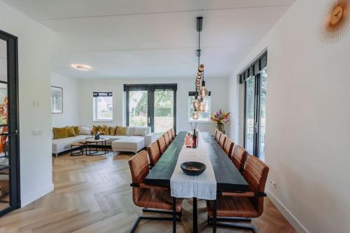 阿姆斯特丹Brand new luxurious 6 bedroom villa in Amsterdam的用餐室以及带桌椅的起居室。