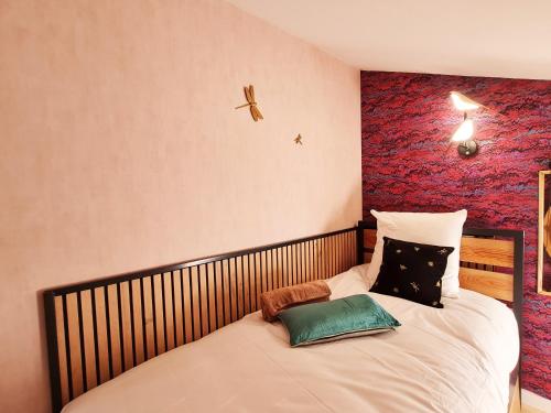 多勒Cabanes du Domaine des Fées的一间卧室配有一张红色墙壁的床