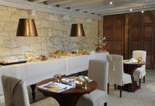 维罗纳Delser Verona Manor House的一间带桌椅和石墙的用餐室
