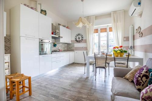 斯培西亚Annali Casa vacanze - Shabby style nella natura的厨房以及带沙发和桌子的客厅。