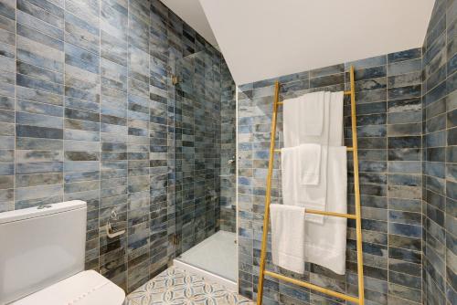 蒙希克Villa Xique 11的浴室设有卫生间和蓝色瓷砖淋浴。