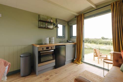 斯内蒂瑟姆Clover Hut - Snettisham Meadows的一间带炉灶的厨房 窗边的顶部烤箱