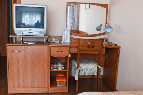 新库兹涅茨克Hotel ABA的一张木桌、一台电视和镜子