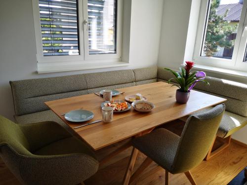 格拉茨Cosy Apartment next to the center of Graz的一张木桌,上面有食物,还有两把椅子