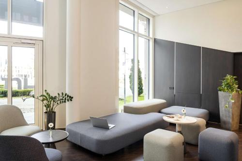 奥伯丁NH酒店慕尼黑机场店的带沙发、椅子和笔记本电脑的客厅