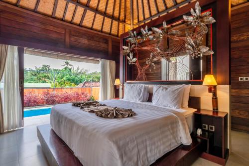 苏卡瓦提Sri Abi Ratu Villas的一间卧室设有一张大床和一个大窗户