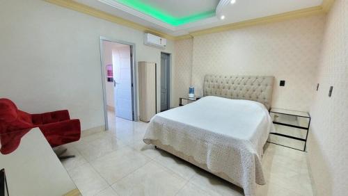帕尔马斯Espetacular apartamento no centro的卧室配有白色的床和红色椅子