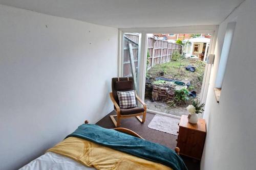 Fornham Saint MartinBeautiful Spacious 5 Bed House的卧室配有床、椅子和窗户。