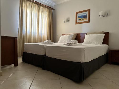 阿尔布费拉BayView Albufeira的一间卧室配有一张带白色床单的大床