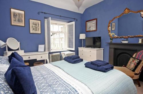 波马利斯Awel y Mor的蓝色卧室设有一张床和一个壁炉