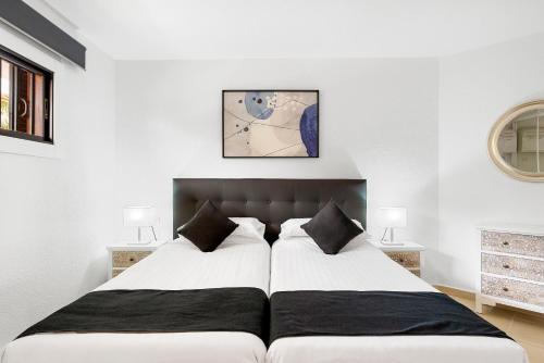 洛斯克里斯蒂亚诺斯鸽子海滩公寓的卧室配有2张床和白色墙壁