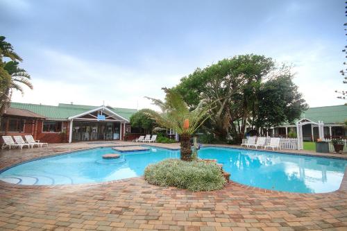 伊丽莎白港松树小屋度假酒店的中间有一个棕榈树的大型游泳池
