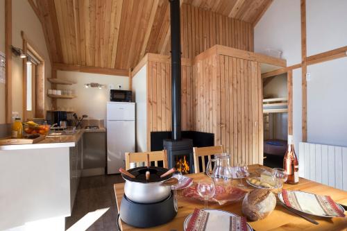 瓦卢伊斯Huttopia Vallouise的厨房配有木桌和炉灶