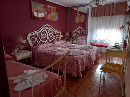 夫罗米斯塔卡密诺圣地亚哥旅馆的一间卧室配有两张床和镜子