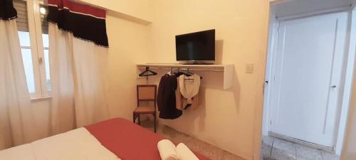 布宜诺斯艾利斯Boedo Tango的一间卧室配有一张床、一台电视和一个窗口