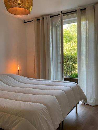 奥贝奈Le Safran的一间卧室设有一张大床和一个窗户。