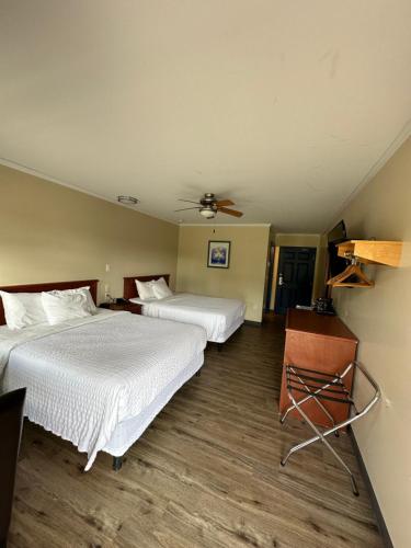 WaasisTravellers Inn Fredericton NB的酒店客房配有两张床和吊扇。