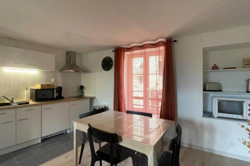 讷沙托Gîte NO 9的厨房配有桌椅和窗户。