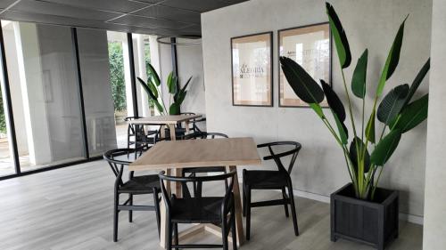 瓦尔迪维亚Apartamento Greta Río CalleCalle的一间带桌椅和盆栽的用餐室
