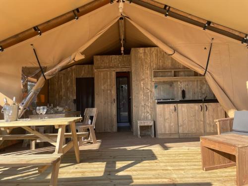 阿维尼翁Lodges & Nature - 49的铺有木地板的帐篷配有桌椅