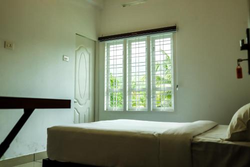 卡尔佩特塔ADONAY INN RESIDENCY的白色的卧室设有床和窗户