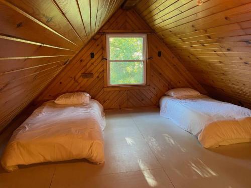 AnnaPrivate cabin, close to town的木间设有两张床,设有窗户