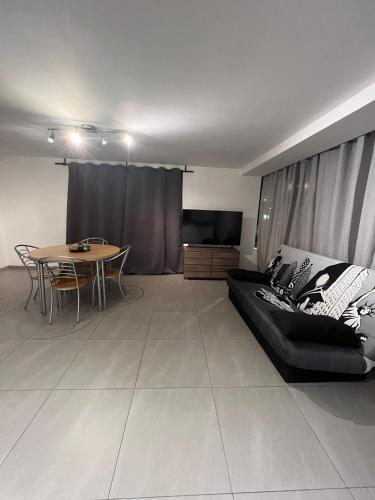 鲁瑟拉勒Alexa Residence - Appartement 1的客厅配有黑色沙发和桌子