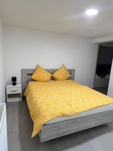 鲁瑟拉勒Alexa Residence - Appartement 1的一间卧室配有一张带黄色棉被和枕头的床